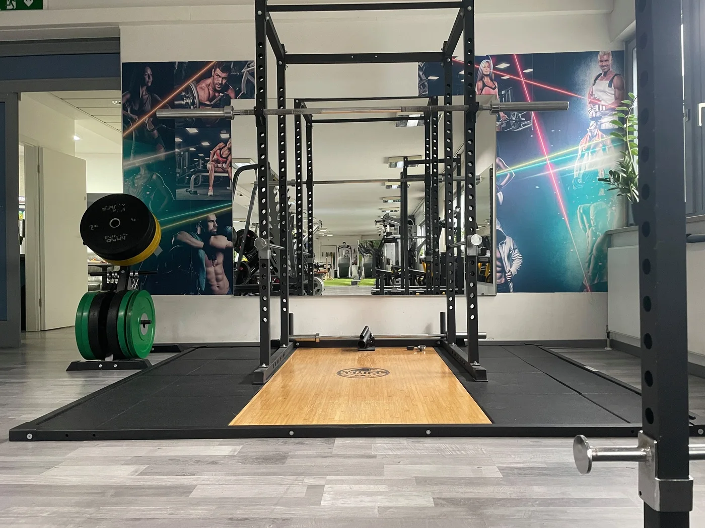 Power Rack mit Hebebühne vor der bedruckten Studiowand
