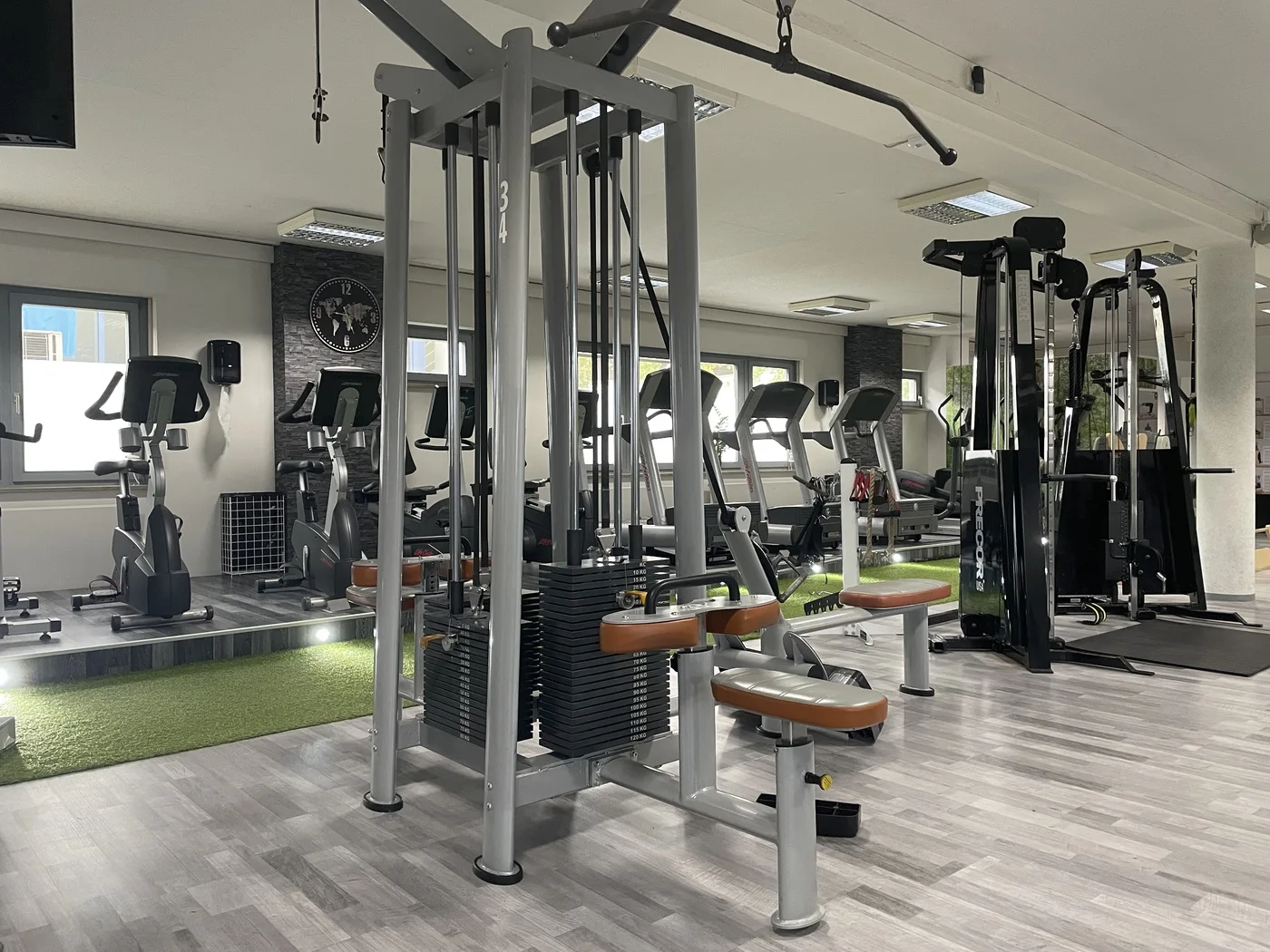Kabelzug- und Kraftgeräte im hellen Trainingsraum